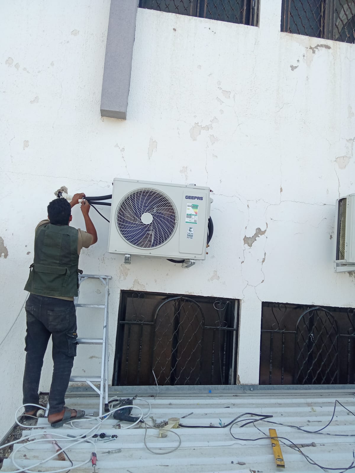 فني مكيفات يقوم بتوصيل وحدة خارجية لمكيف سبليت جيباس بالطائف